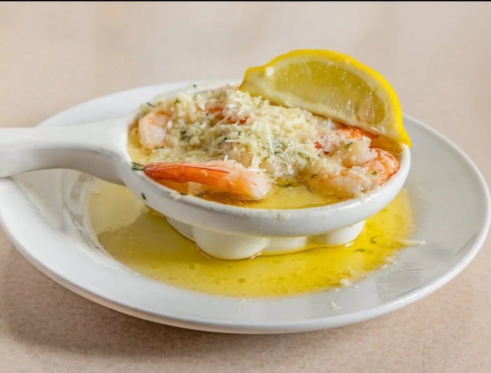 Shrimp served in a white dish with lemon
