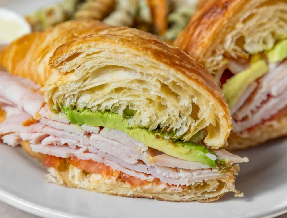 Croissant sandwich with sliced turkey and avocado